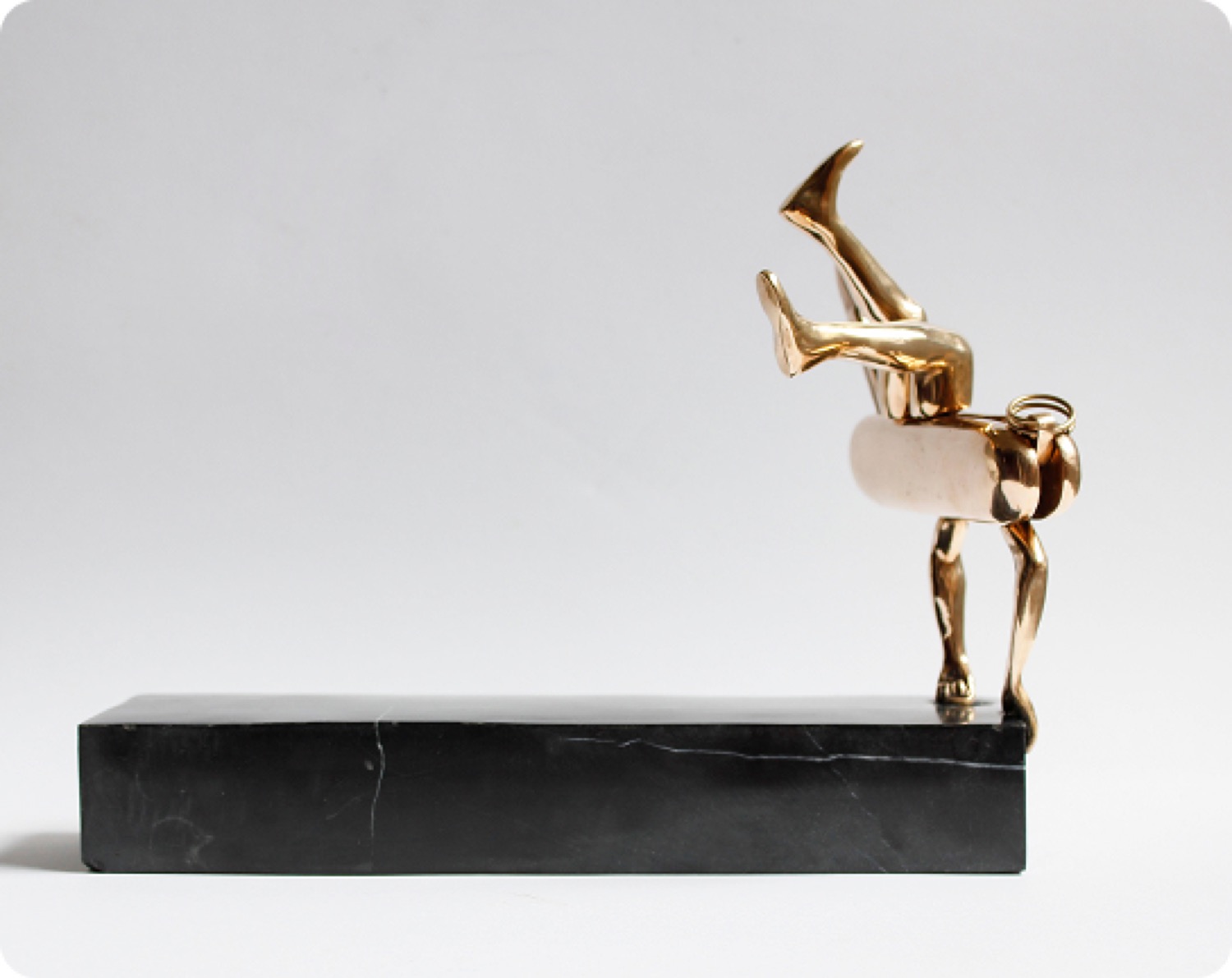 Edge: a bronze figure tipping forward on a long black base