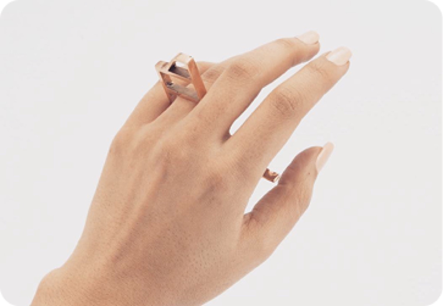 A raised hand wearing a slim gold ring