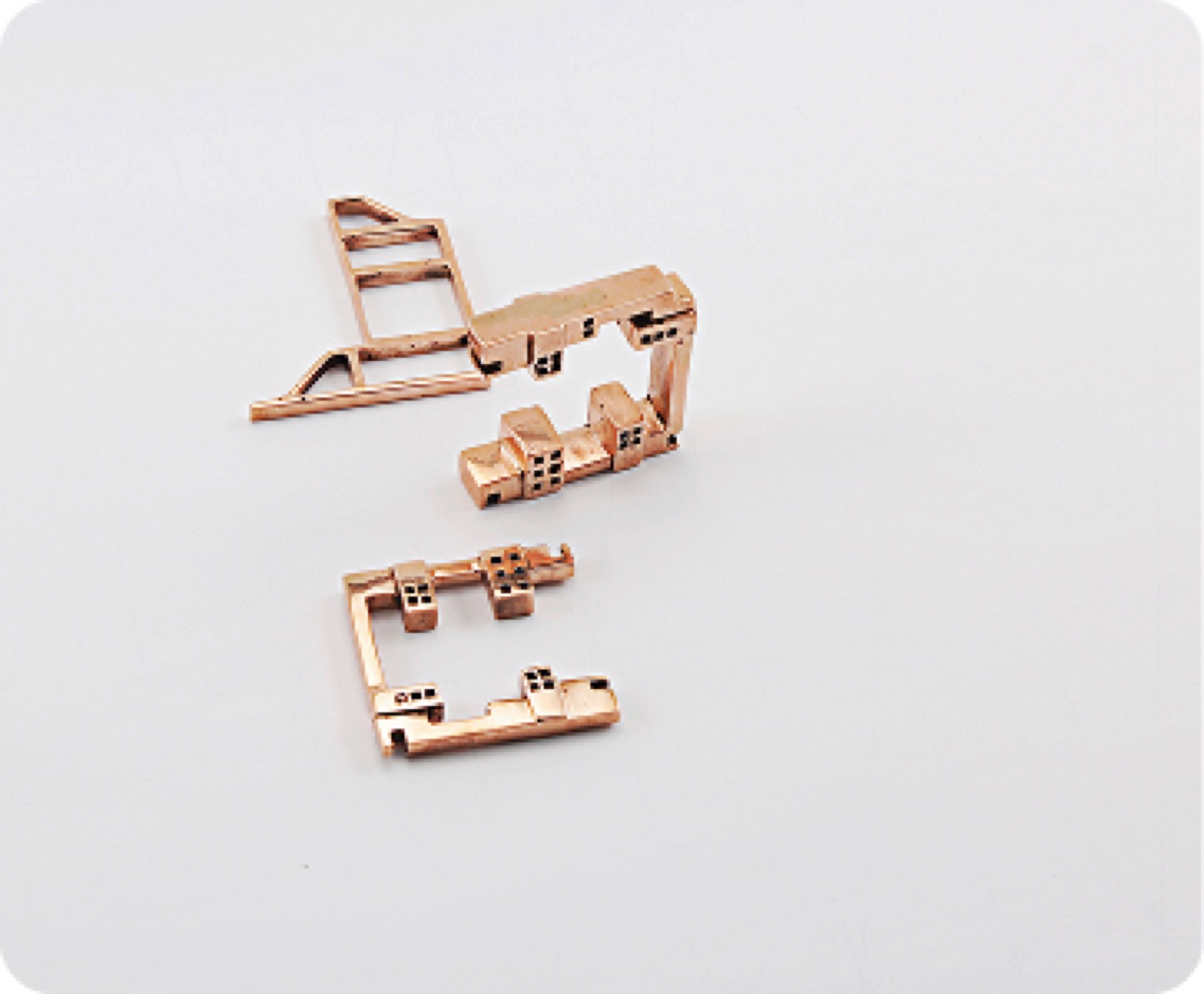Two gold pieces laid flat, showing their built forms