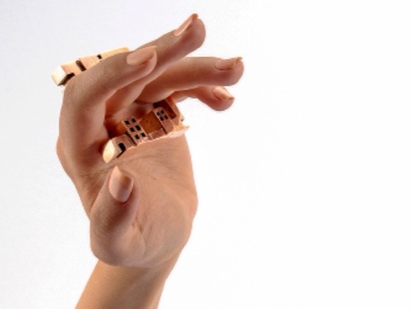 Architectural gold rings worn across the fingers